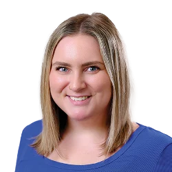 A woman with shoulder-length blonde hair smiles, wearing a blue top, against a solid black background.